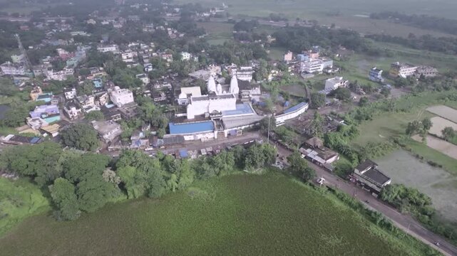 Wide aerial drone shot of Chhatia Bata Jagannath Temple surrounded by greenery in Odisha, India.