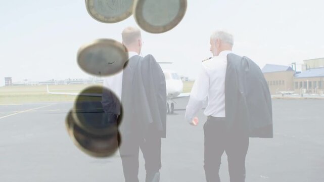 Walking pilots with jackets toward jet on apron for flight, coins entering from upper-left
