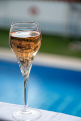 Fototapeta premium Drinking of Champagne or cava sparkling wine at holiday resort on poolside on winter sun vacation on Tenerife, Canary Islands travel destination, Spain