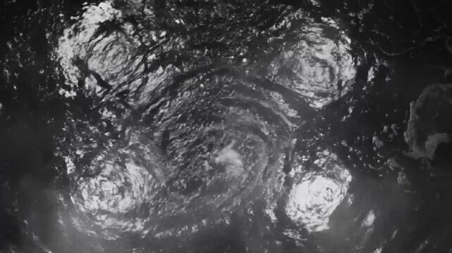 Abstract aerial view of swirling dark water revealing circular patterns in the unknown depth
