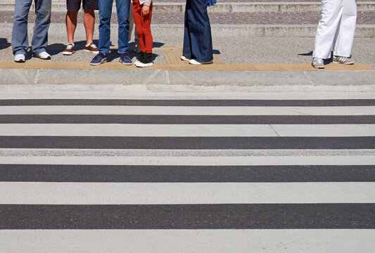 group of unrecognizable people standing at crossroad and waiting to cross the city street