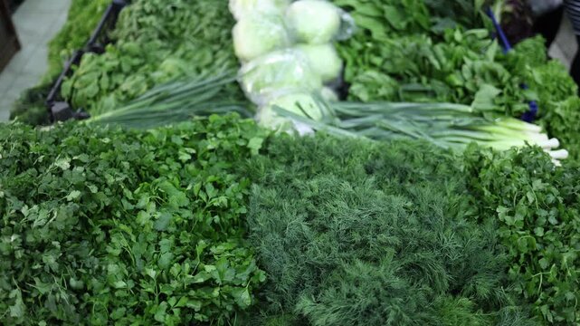 Fresh green herbs parsley and dill arranged in market stall creating dense natural texture vibrant color and healthy organic food concept