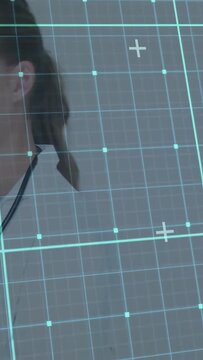 Vertical video: Reading to patient Dr in coat with steth exiting as teal grid rising, copy space