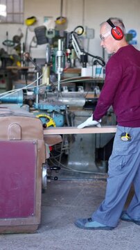 Experienced carpenter using industrial wood sander