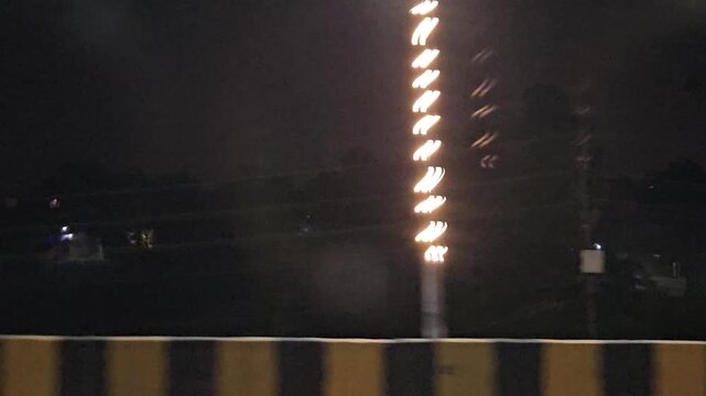 Night traffic on busy urban road with cars, buses and street lights, long queue of vehicles under dark sky, transportation and travel scene showing motion, infrastructure evening city life in India