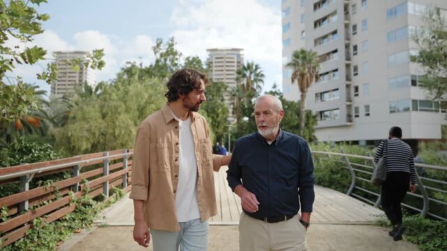 Happy senior father with adult son embracing, walking enjoying day in the city. Smiling, talking. Family love, bonding 