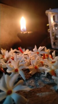Traditional Oil Lamp with Night Jasmine Flowers Burning in Dark Spiritual Background