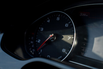 Fototapeta premium Car tachometer gauge showing engine speed with needle indicator, close up of instrument cluster and dashboard display.