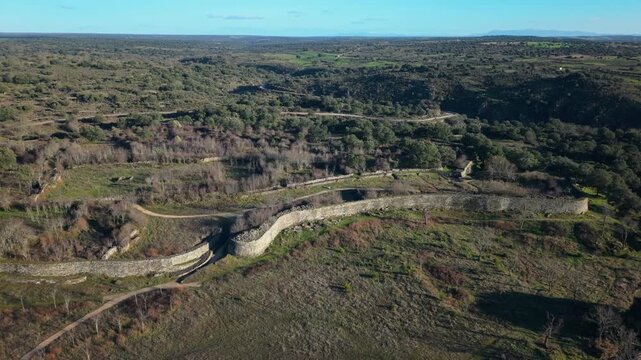 Aerial orbiting shot revealing the ancient stone wall and the main gate of the iron age settlement of Yecla la Vieja, a castro of Veton origin in Salamanca, Spain