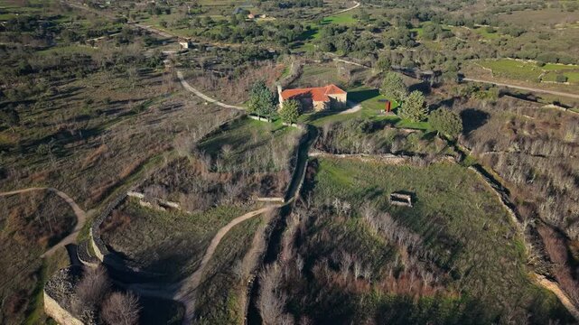 Aerial orbiting shot of the ancient Vetton castro Yecla la Vieja revealing the historic walls and hermitage in Yecla de Yeltes, Salamanca, Spain, a cultural interest site
