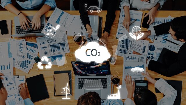 A diverse group of professionals collaborates during a meeting focused on climate action and CO2 reduction, analyzing data on sustainability initiatives and strategies. Raster