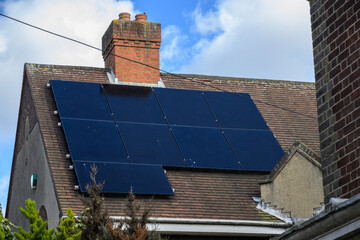 House roof with solar panels generating renewable energy UK © Jon