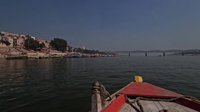 View from a moving boat on the Ganges River at Varanasi Ghats. Sacred river, historic Ghats, and spiritual atmosphere, showcasing Indian culture, rituals, and timeless heritage. Uttar Pradesh, India