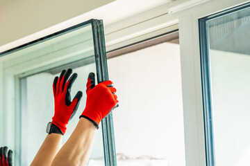 Removed triple glazed window glass unit leaning near frame after replacement in apartment. Broken...