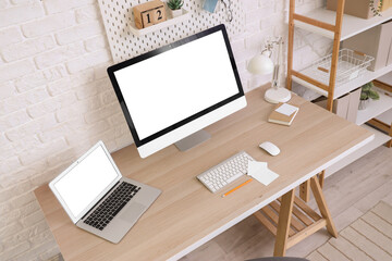 Fototapeta premium Workplace with blank computer monitor and laptop in office