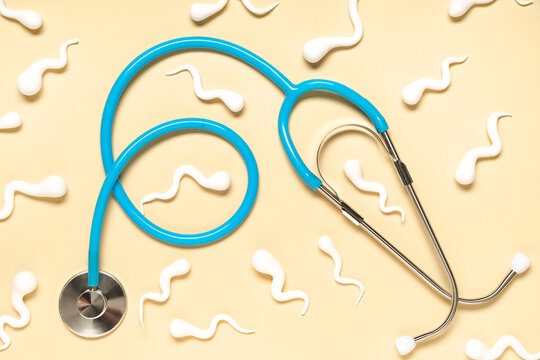 Sperm cells with stethoscope on beige background