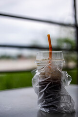 Thai Iced Black Coffee In Plastic Cup Left On Table Until Ice Melts