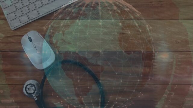 Animation of digital globe over stethoscope, computer keyboard and mouse on table