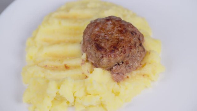 Homestyle cutlet with mashed potatoes. Golden seared cutlet on creamy mashed potatoes. Appetizing homemade cutlet perched atop smooth mashed potatoes with rustic charm