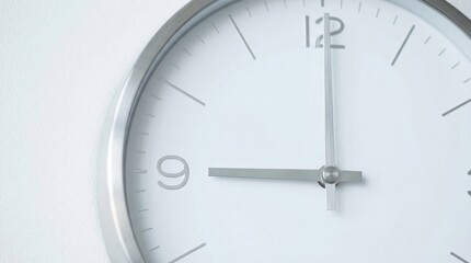 Fototapeta premium Minimalist clock showing nine o'clock on white wall, symbolizing punctuality and time management in modern office
