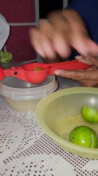 Placing half a lemon into a red squeezer