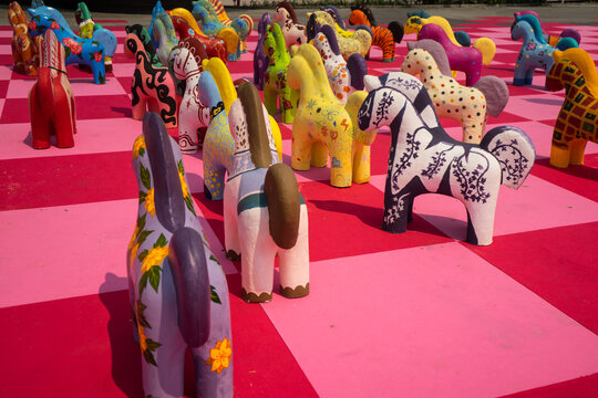 Colorful Paper mache horses displayed on the pink floor that Horse is the Chinese zodiac sign.