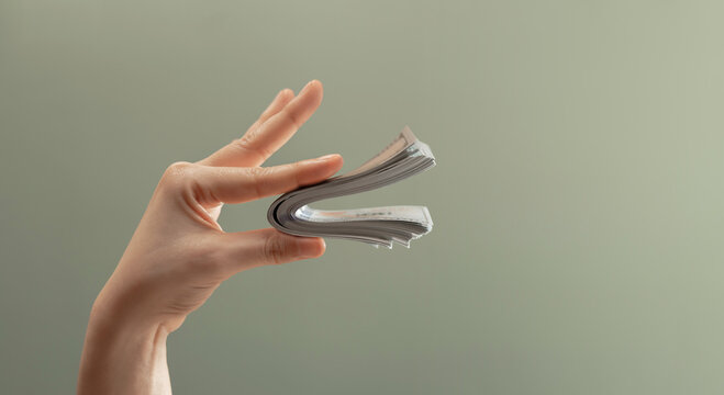 Hand holding bundle banknotes shaped like speaking mouth. Money talks, financial power