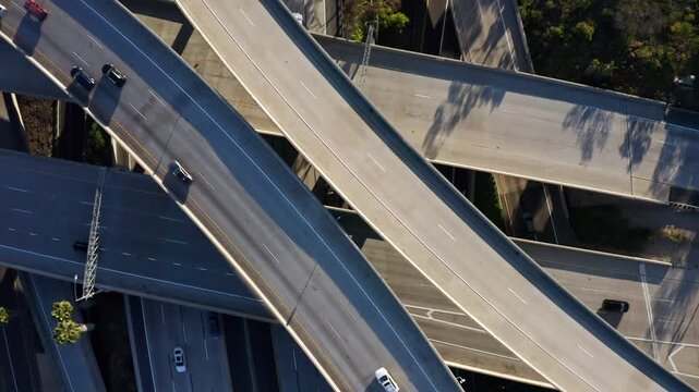 Aerial view of cars driving on complex freeway interchange overpasses and bridges in urban landscape