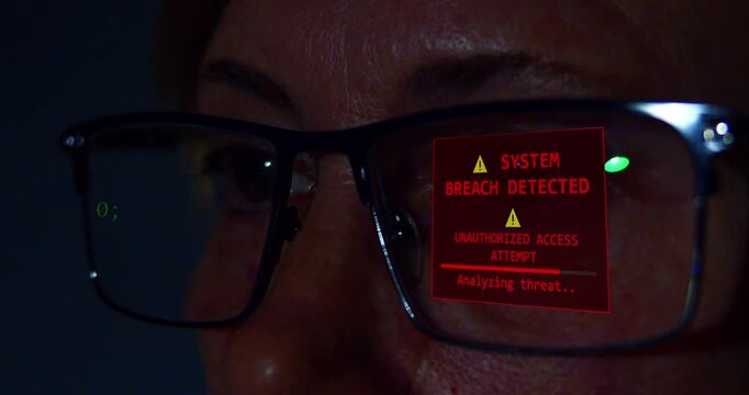 Close-up of a focused programmer or data scientist wearing glasses analyzing code on a screen and an unauthorized login attempt.