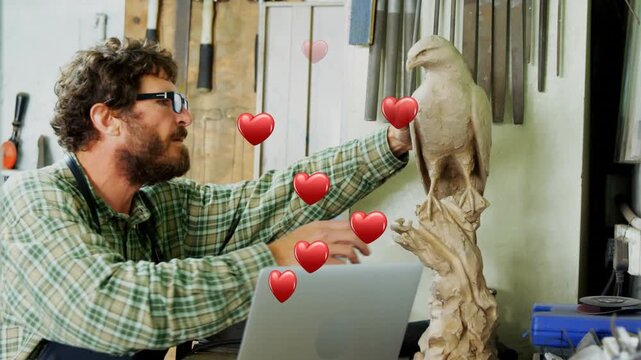 Animation of heart icons over caucasian male worker inspecting carving