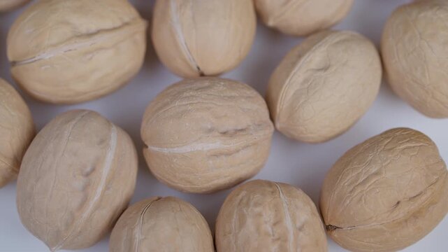 Highresolution image showcasing packed walnut shells with subtle shadows. Crisp closeup photograph displaying embossed walnut shells illuminated by soft natural lighting