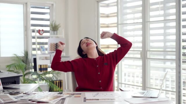 Female adult professional working from home massaging sore neck because of prolonged screen time at modern office desk
