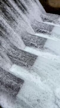 Water flowing down a stepped spillway of a reservoir dam representing renewable energy and power generation