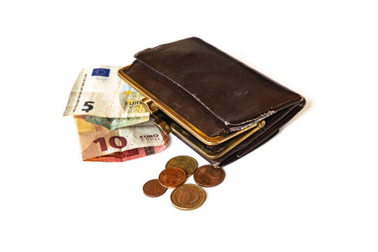 An old worn out leather purse with few euro notes and coins against white background