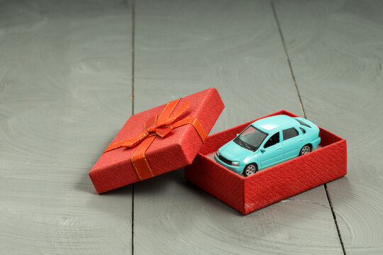 Blue toy car inside open gift box, present and surprise concept