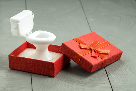 Open red gift box revealing miniature toilet, novelty gift and bathroom humor theme