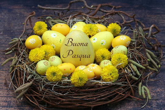 Auguri di Pasqua italiani &ldquo;Buona Pasqua&rdquo; su un grande uovo giallo in un nido rustico con fiori gialli.