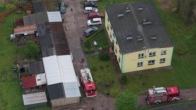 Volunteer firefighters from a rural Polish village celebrating Wet Monday (Śmigus-Dyngus), joyfully splashing water and playing with local residents in a festive spring tradition