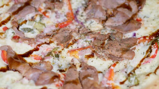 Mouthwatering closeup of delicious glazed meat topped pizza with crispy crust. Visually appealing image showcasing delectable pizza with rich toppings and perfectly crispy base