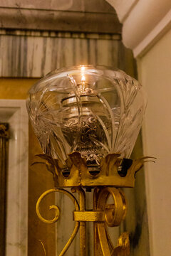 Ornate Antique Glass Lamp With Gold Metal Stand and Warm Glowing Light in Interior