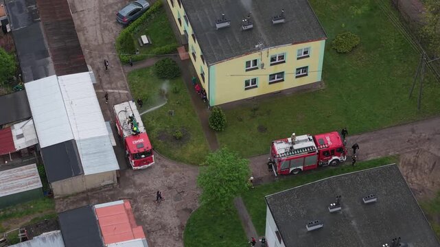 Volunteer firefighters from a rural Polish village celebrating Wet Monday (Śmigus-Dyngus), joyfully splashing water and playing with local residents in a festive spring tradition