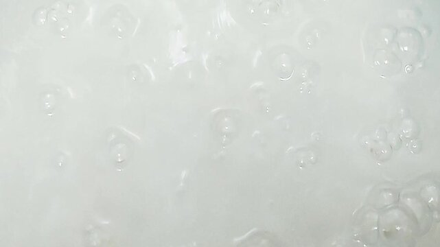 Close-up of rice porridge boiling softly, simple homemade meal in a kitchen setting.