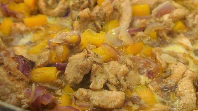In a deep cast-iron skillet, chicken is fried in vegetable oil with teriyaki sauce