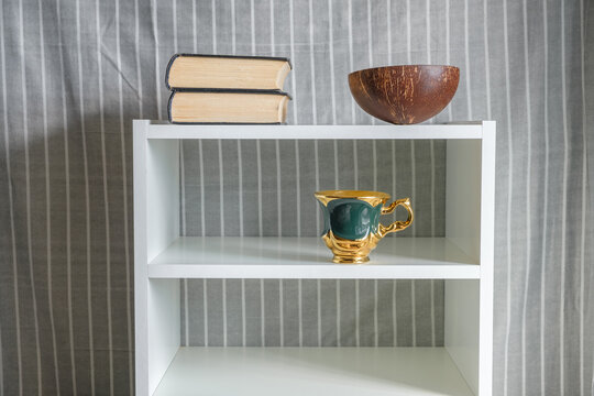 dishes and books on the white shelves of the shelf