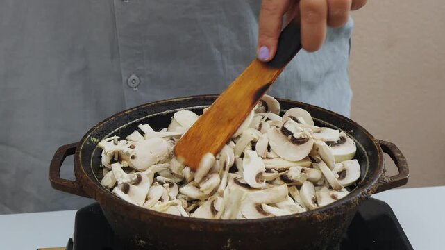 In a deep cast-iron skillet, chicken is fried in vegetable oil