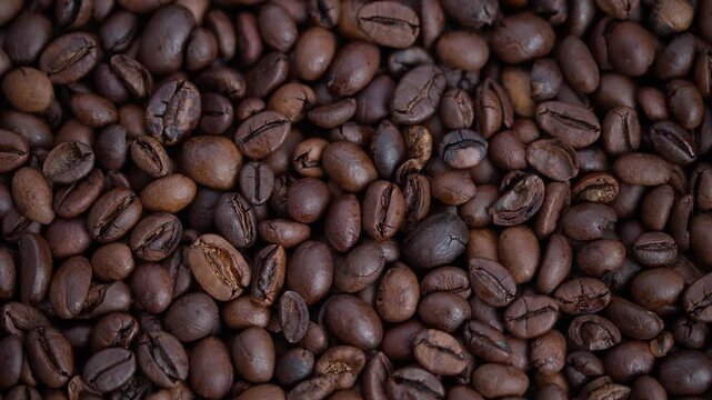 Closeup of glossy roasted coffee beans, Detailed macro image illustrating shiny dark roasted coffee beans with surface cracks and color differences suitable for branding