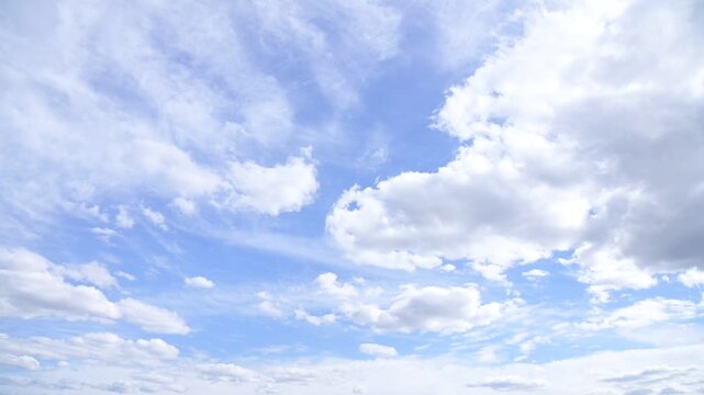 White clouds float across the blue sky