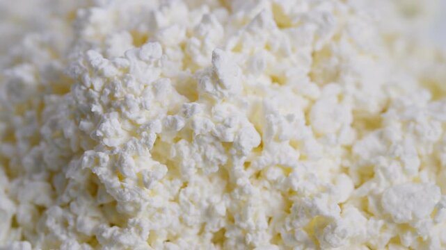 Cheese texture closeup, Detailed view of cottage cheese texture and color, Macro image capturing delicate curd grains with gentle lighting and minimal background elements