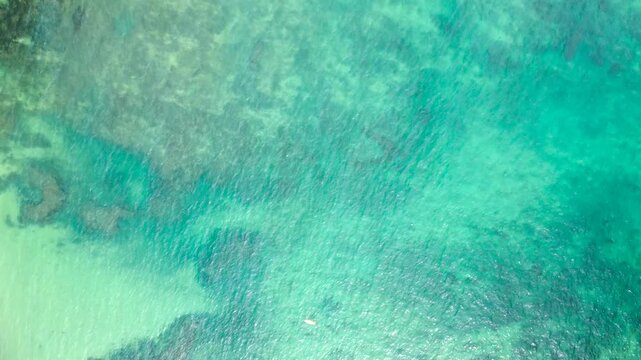 Clear turquoise ocean water and submerged volcanic reef formations viewed from a top-down aerial perspective on S&atilde;o Tom&eacute; Island, S&atilde;o Tom&eacute; and Pr&iacute;ncipe.