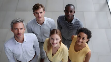 Fototapeta premium A diverse group of smiling professionals looking up together in a modern office setting